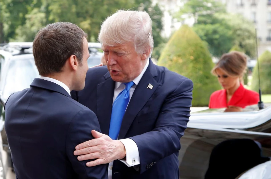 Ông Macron (trái) chào mừng ông Trump tại điện Invalides ngày 13-7. Ảnh: REUTERS
