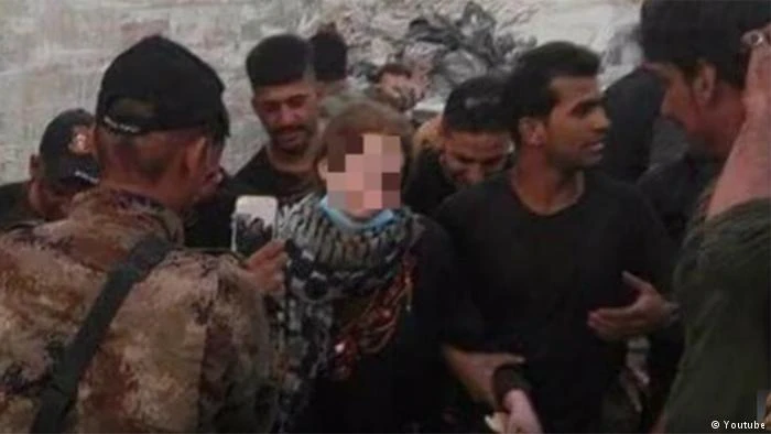 Các binh sĩ Iraq chụp hình với nữ sinh Đức Linda W. (che mặt) sau khi bắt cô. Ảnh: Deutsche Welle