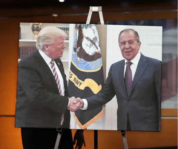 Phe Dân chủ trưng hình ảnh Tổng thống Mỹ Trump chào mừng Ngoại trưởng Nga Sergei Lavrov trong một cuộc họp báo tại Nhà Trắng. Cuộc gặp diễn ra chỉ một ngày sau khi ông Trump sa thải Giám đốc FBI James Comey. Ảnh: GETTY IMAGES