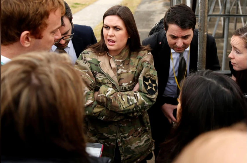 Người phát ngôn Nhà Trắng Sarah Sander (mặc áo quân nhân cho đỡ lạnh) thông báo tình hình với các nhà báo về chuyến thăm khu quân sự bất thành của Tổng thống Trump, sáng 8-11. Ảnh: REUTERS