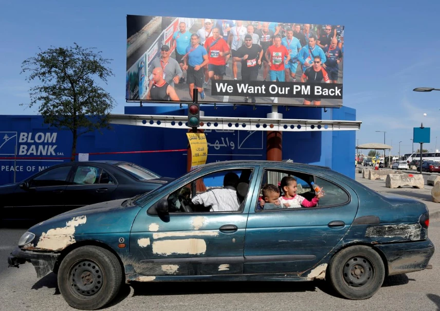 Áp phích “Tôi muốn Thủ tướng chúng tôi quay lại” được trưng tại thủ đô Beirut (Lebanon) trong ngày chạy bộ hàng năm Beirut Marathon 12-11. Ảnh: REUTERS