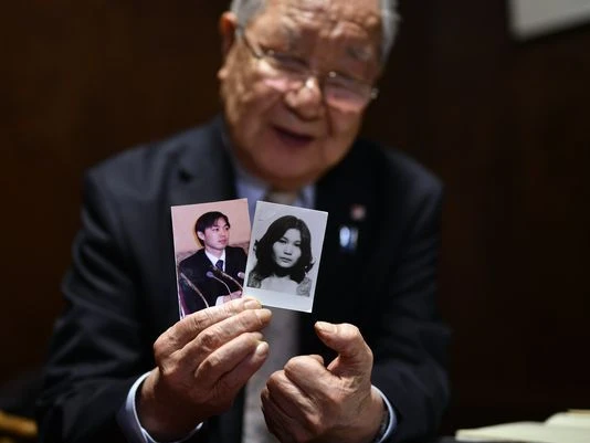 Shigeo Lizuka, 79 tuổi, nhóm trưởng một nhóm gia đình có người thân bị Triều Tiên bắt đi, trưng hình ảnh em gái và con trai trong cuộc phỏng vấn ở Tokyo (Nhật) ngày 3-12. Ảnh: EPA