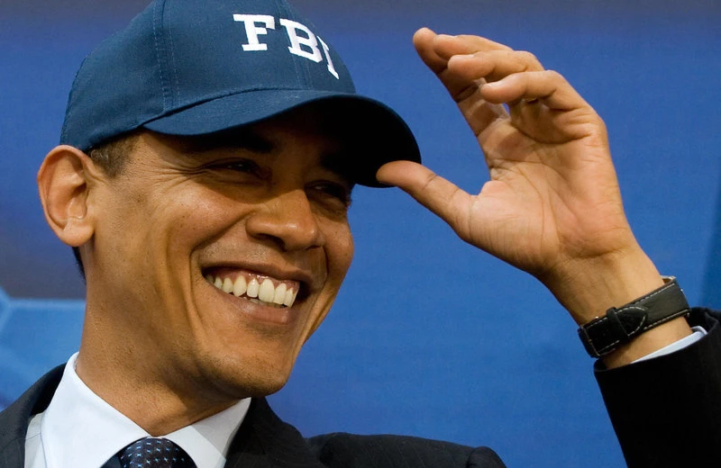 Tổng thống Obama đội một cái mũ FBI do Giám đốc FBI khi đó là ông Mueller trong chuyến thăm đến trụ sở chính của FBI ở thủ đô Washington (Mỹ) tháng 4-2009. Ảnh: AFP