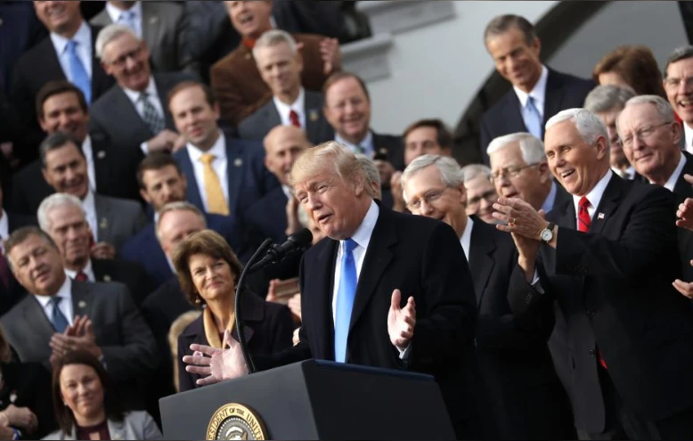 Tổng thống Mỹ Donald Trump (giữa) ăn mừng thực hiện được một cam kết tranh cử lớn: cải cách thuế, tại cuộc họp nội các ở Nhà Trắng ngày 20-12. Ảnh: REUTERS