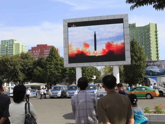 Người dân Bình Nhưỡng (Triều Tiên) xem bản tin về một vụ thử tên lửa của nước này, tháng 9-2017. Ảnh: AP