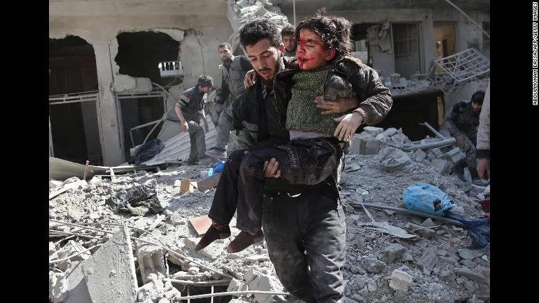 Nhân viên tình nguyện cứu hộ nạn nhân trẻ em tại Đông Ghouta ngày 21-2. Ảnh: CNN