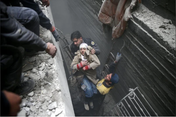 Cứu hộ một phụ nữ bị hôn mê từ dưới hầm trú ẩn ở thị trấn Douma, Đông Ghouta (Syria) ngày 22-2. Ảnh REUTERS