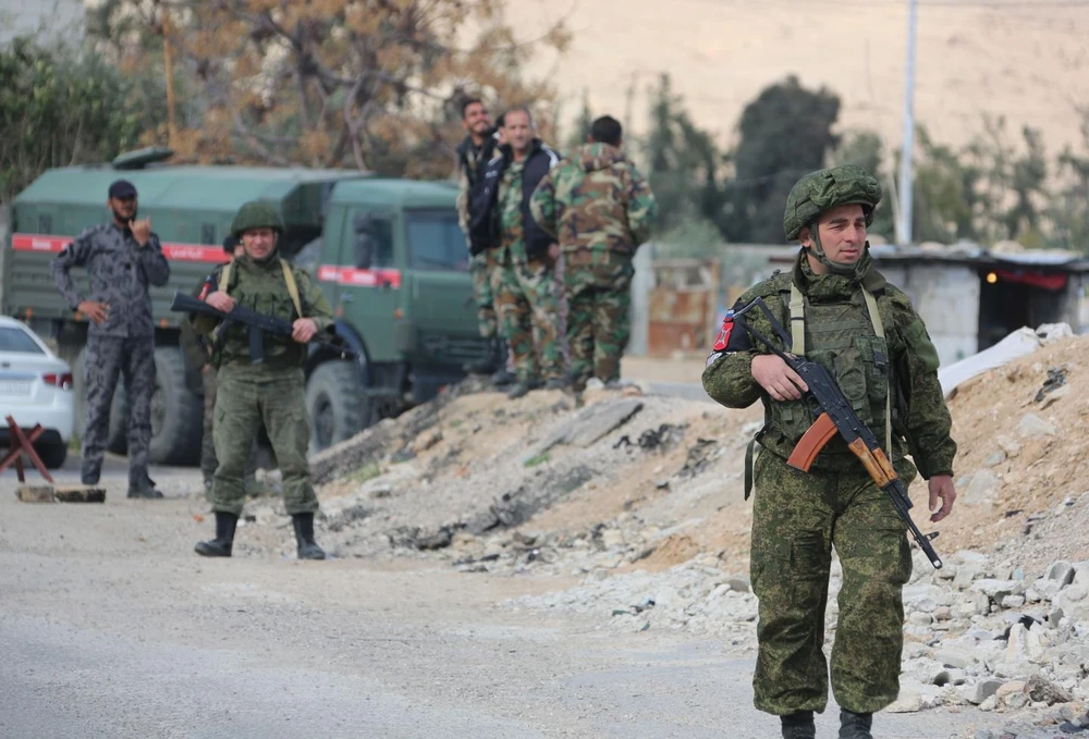 Quân cảnh Nga và binh sĩ Syria tại một chốt kiểm soát gần Đông Ghouta, ngoại ô thủ đô Damascus (Syria) ngày 9-3, thực hiện nhiệm vụ đưa dân thường sơ tán khỏi vùng giao tranh này. Ảnh: AFP