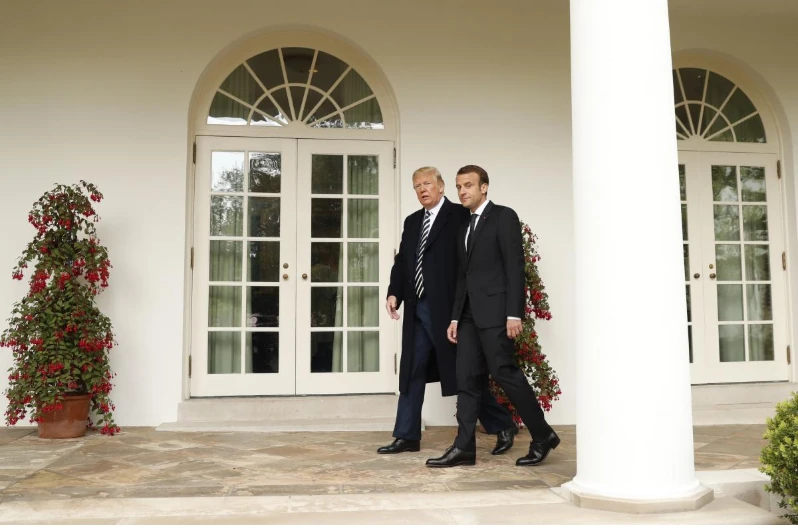 Tổng thống Mỹ Donald Trump (trái) và Tổng thống Pháp Emmanuel Macron bước dọc hành lang Nhà Trắng về phòng Bầu dục hội đàm song phương sau lễ đón chính thức ngày 24-4. Ảnh: REUTERS