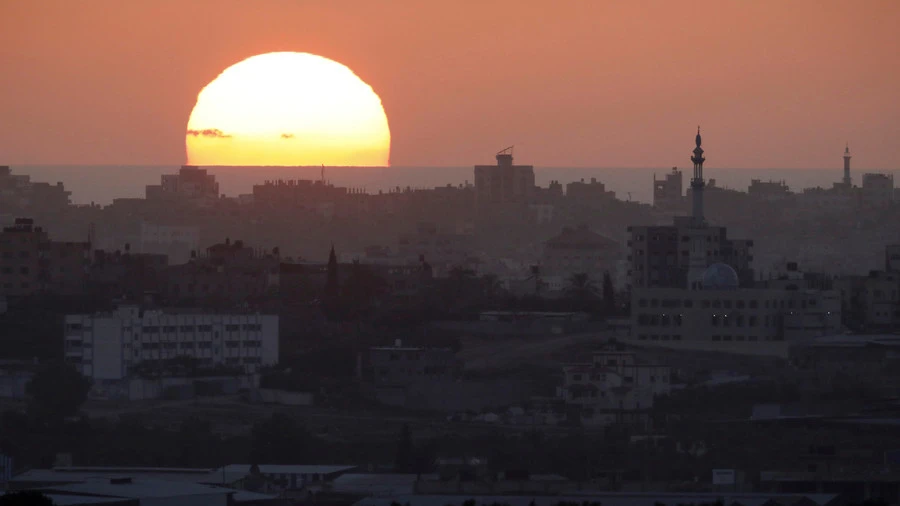 Mặt trời mọc trên Dải Gaza. Hàng loạt cơ sở quân sự của Hamas ở Dải Gaza vừa hứng không kích của Israel. Ảnh: REUTERS