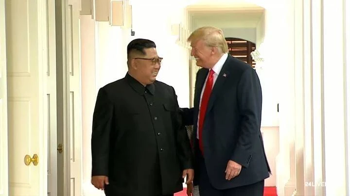 Tổng thống Mỹ Donald Trump (phải) và lãnh đạo Triều Tiên Kim Jong-un cười với nhau, bắt đầu cuộc gặp riêng từ 9 giờ sáng 12-6 tại khách sạn Capella ở Singapore. Ảnh: CNA