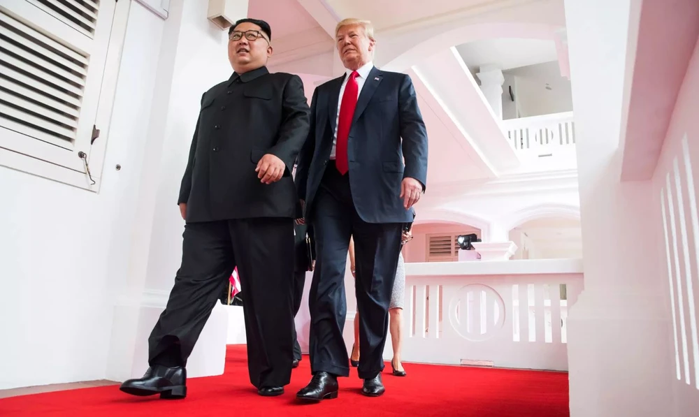 Ông Kim (trái) và ông Trump (phải) cùng nhau bước vào phòng gặp song phương sáng 12-6. Ảnh: NYT