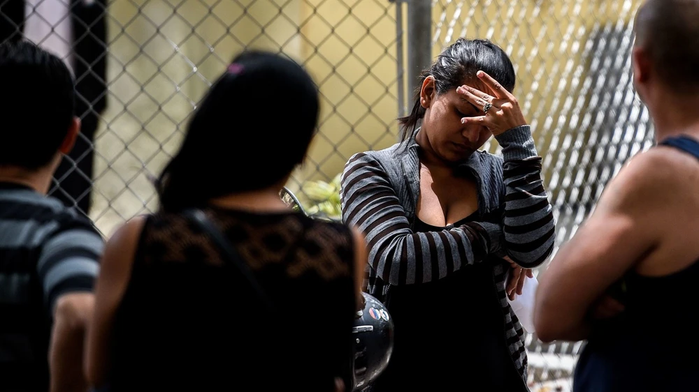 Người thân nạn nhân thiệt mạng vì dẫm đạp tại hộp đêm chờ đón thi thể con em mình được đưa về một nhà xác bệnh viện ở Caracas (Venezuela) ngày 16-6. Ảnh: GETTY IMAGES