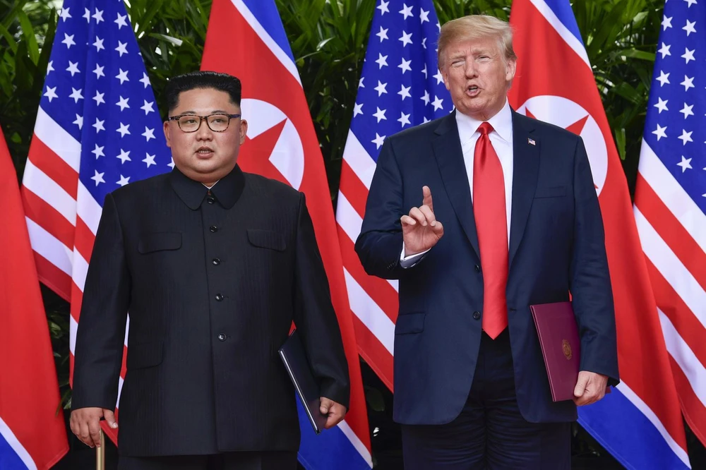Tổng thống Mỹ Donald Trump (phải) và lãnh đạo Triều Tiên Kim Jong-un (trái) trong lễ ký tuyên bố chung thượng đỉnh Mỹ-Hàn ngày 12-6 tại Singapore. Ảnh: AP