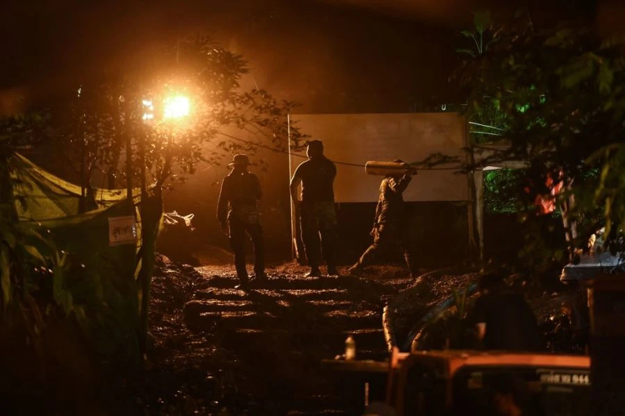 Lực lượng cứu hộ mang bình oxy vào hang động Tham Luang cung cấp cho các thành viên đội bóng nhí, khuya 2-7. Ảnh: GETTY IMAGES