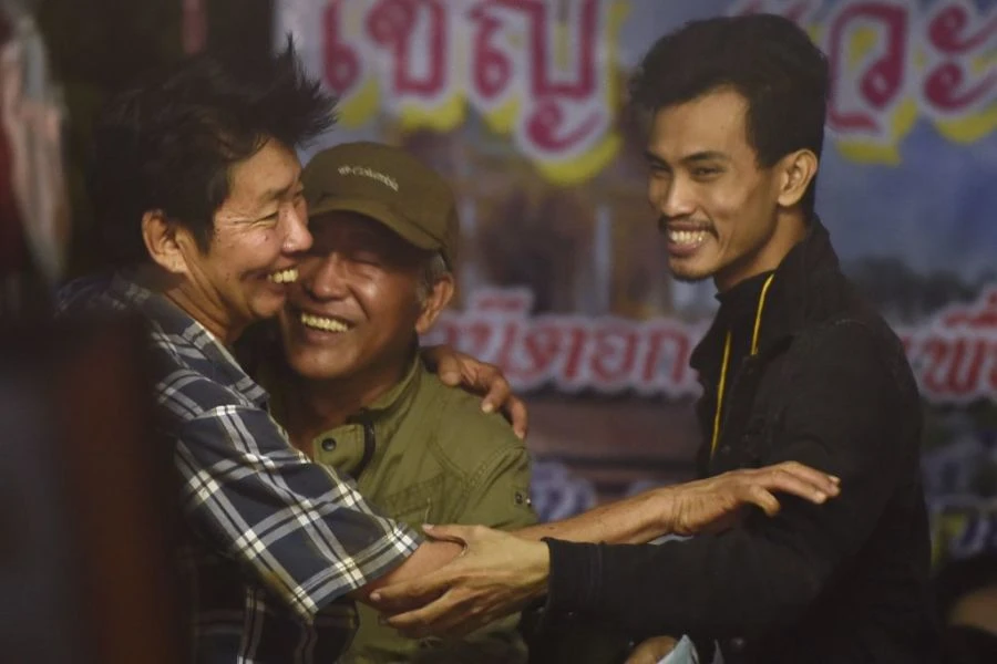 Cha mẹ các cầu thủ nhí chia sẻ niềm vui tột cùng bên ngoài hang động Tham Luang khuya 2-7, sau 9 ngày hồi hộp chờ tin tức con mình. Ảnh: GETTY IMAGES