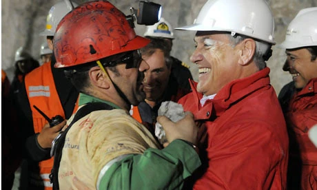 Ông Florencio Ávalos, thợ mỏ đầu tiên được cứu lên mặt đất được Tổng thống Chile Sebastian Pinera ôm xiết chào mừng. Ảnh: REX 