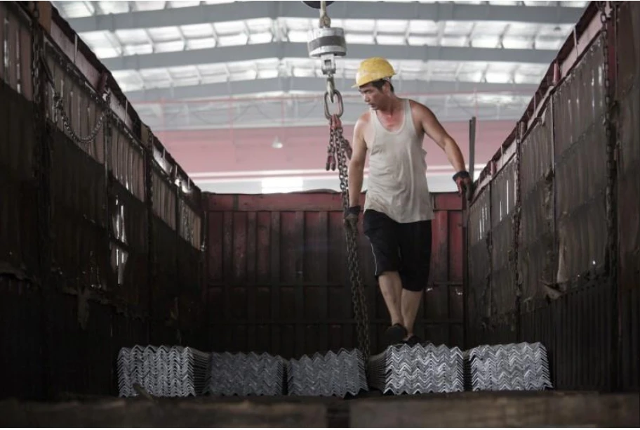 Công nhân sắp xếp thép thành phẩm lên một xe tải tại một nhà kho ở của tập đoàn thép Baifeng Iron and Steel Corporation ở tỉnh Hà Bắc (Trung Quốc). Ảnh: REUTERS