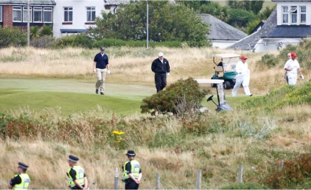 Tổng thống Mỹ Donald Trump (áo khoác đen, nón trắng) tại khu nghỉ dưỡng đánh golf của mình ở Turnberry (Scotland) ngày 14-7. Ảnh: REUTERS
