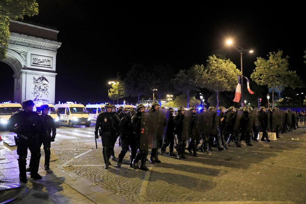 Cảnh sát chống bạo động đang thực hiện nhiệm vụ tại đại lộ Champs Elysees, Paris sau khi Pháp thắng Bỉ 1-0 ngày 10-7. Ảnh: REUTERS