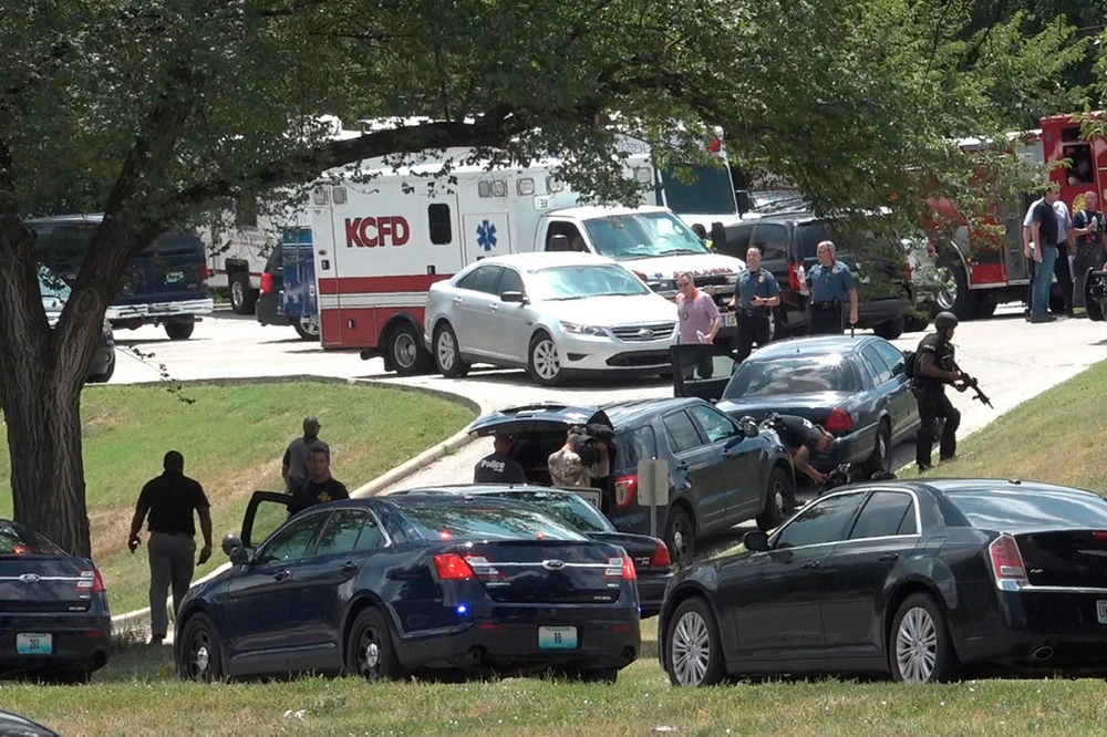 Cảnh sát điều tra tại hiện trường thứ hai của vụ án - giao lộ ở TP Kansas, bang Missouri (Mỹ), nơi tên cướp trốn vào một ngôi nhà sau khi bắn bị thương 2 cảnh sát ngày 15-7. Ảnh: AP
