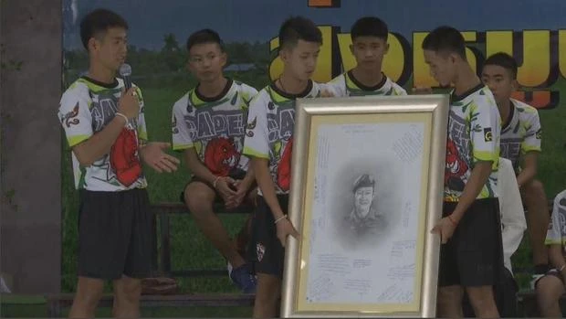 Các cậu bé và bức di ảnh cựu đặc nhiệm Thai Navy Seals Saman Kunan tại cuộc họp báo. Ảnh: REUTERS