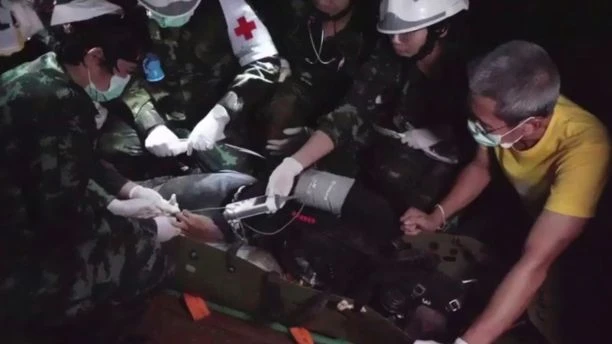 Một cậu bé được đưa lên cáng di chuyển qua đoạn không ngập nước trong hang động Tham Luang. Ảnh: THAI NAVY SEALS