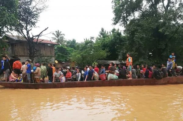 Người dân Lào sơ tán bằng thuyền ra khỏi khu vực bị ngập sau khi một con đập phụ thuộc sự án thủy điện Xe Pian Xe Nam Noy bị vỡ, ngày 24-7. Ảnh: ABC LAOS NEWS