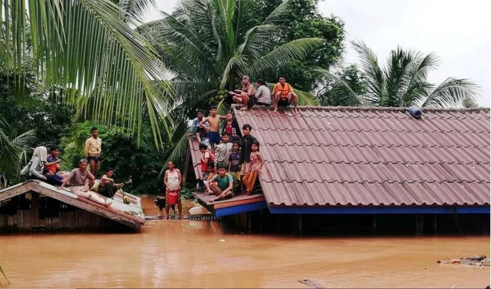 Hơn 3.000 người vẫn đang chống chọi với nước lũ, chờ được cứu. Ảnh: REUTERS