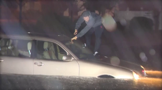 Người dân cố thoát ra khỏi một chiếc xe ngập trong nước ở TP Wilmington, bang North Carolina (Mỹ). Ảnh: CBS NEWS