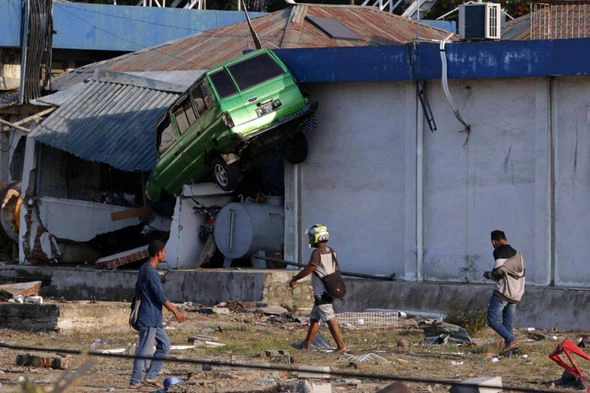 Xe bị sóng thần cuốn vào nhà. Ảnh: EXPRESS