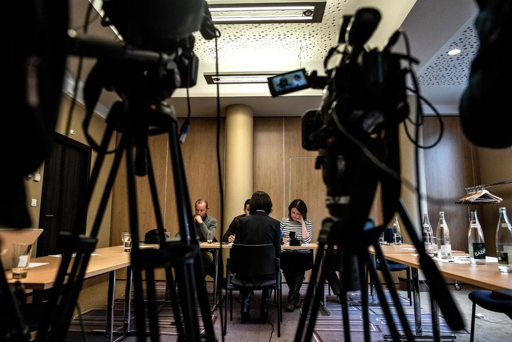 Bà Grace Mạnh, vợ ông Mạnh Hoàng Vĩ (ngồi quay lưng) trao đổi với báo chí về chuyện chồng mình mất tích sau khi từ Pháp trở về Trung Quốc, trong cuộc họp báo ở Lyon (Pháp) ngày 7-10. Ảnh: GETTY IMAGES