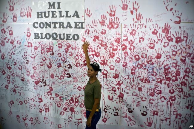 Một phụ nữ đứng trước bức tranh vẽ tường ở Havana (Cuba) ngày 31-10 nhân sự kiện vận động phản đối lệnh cấm vận kinh tế của Mỹ với Cuba. Ảnh: AP