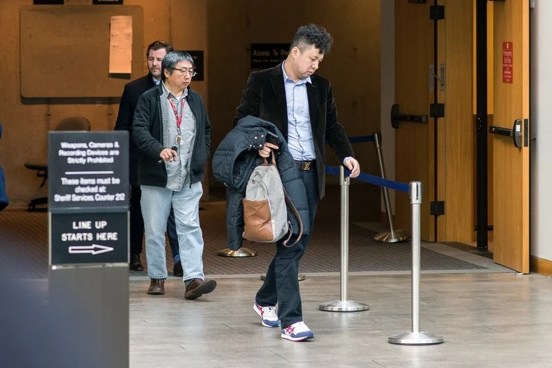 Chồng bà Mạnh Vãn Châu, ông Lưu Hiểu Tông (giữa) đến phiên tòa xét xử vợ ở Vancouver ngày 10-12. Ảnh: BLOOMBERG