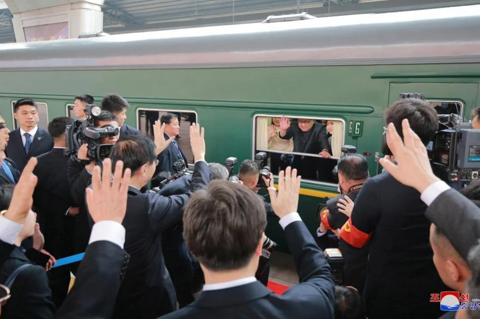 Lãnh đạo Triều Tiên Kim Jong-un (giữa, trên tàu) vẫy chào mọi người bên dưới trong một chuyến tàu lửa đến thăm Trung Quốc. Ảnh: KCNA công bố tháng 3-2018