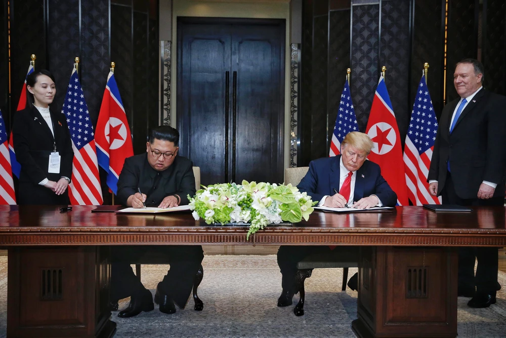 Tổng thống Mỹ Donald Trump (phải) và lãnh đạo Triều Tiên Kim Jong-un ký tuyên bố chung trong cuộc gặp thượng đỉnh đầu tiên ở khách sạn Capella (Singapore) ngày 12-6-2018. Ảnh: AFP
