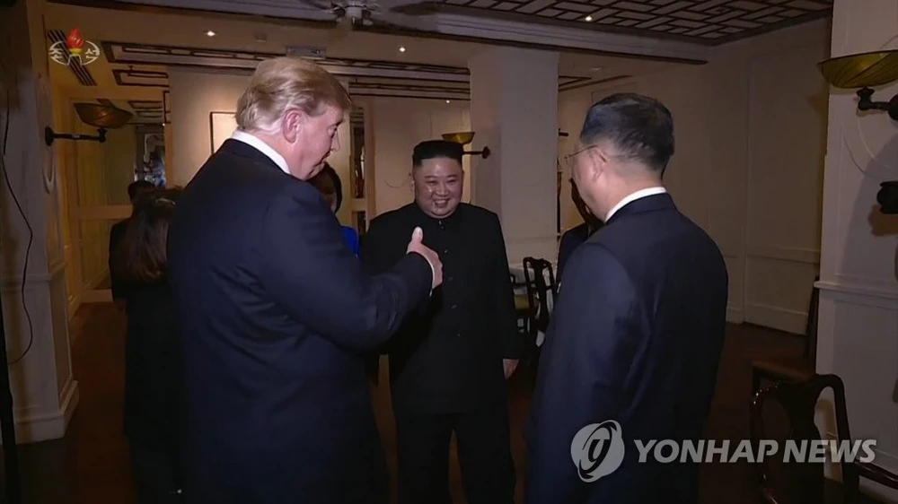 Tổng thống Mỹ Donald Trump (trái) giơ ngón tay chào Phó Chủ tịch Đảng Lao động Triều Tiên Kim Yong-chol (phải) trong lúc lãnh đạo Triều Tiên Kim Jong-un đứng kế bên khi hai bên gặp nhau chuẩn bị cùng dùng bữa tối 27-2. Ảnh: YONHAP chụp lại từ màn hình đài truyền hình trung ương Triều Tiên KCTV