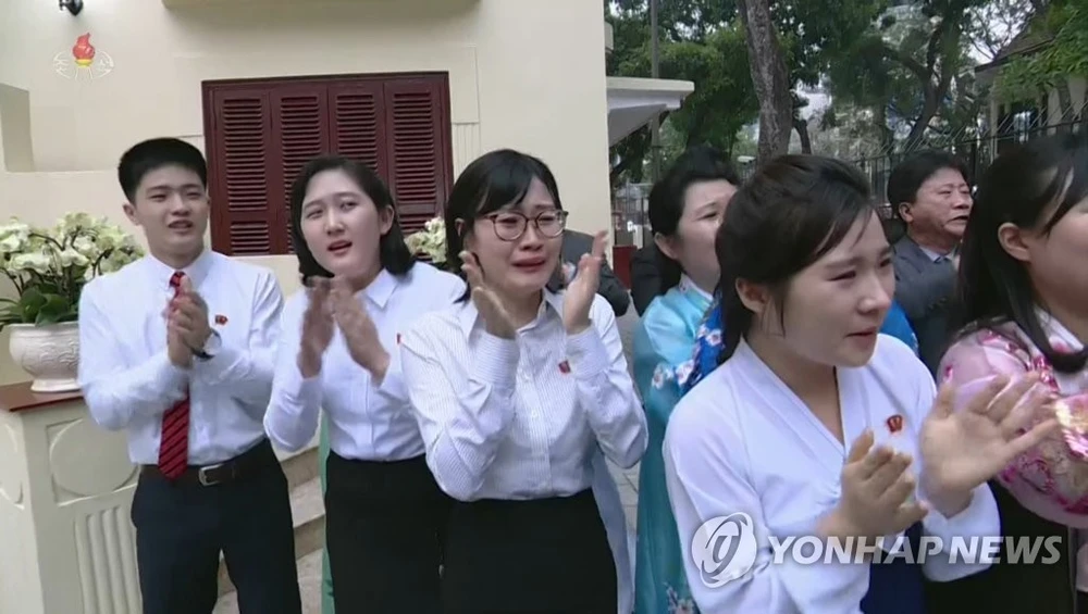 Người dân Triều Tiên xúc động khi nhìn thấy lãnh đạo Kim Jong-un đến thăm Đại sứ quán Triều Tiên ở Hà Nội chiều 27-2. Ảnh: YONHAP chụp lại từ màn hình đài truyền hình trung ương Triều Tiên KCTV