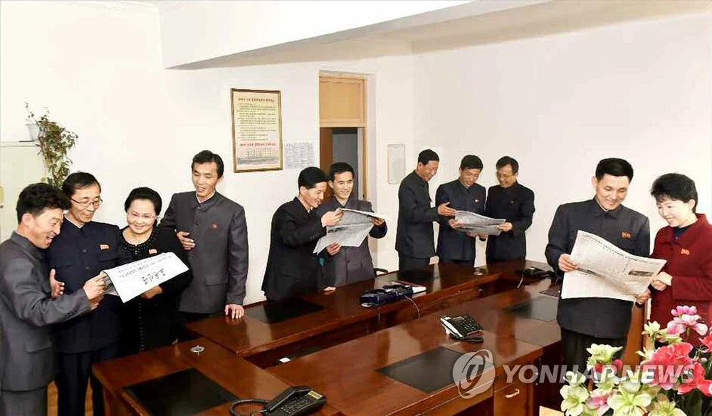 Công chức Triều Tiên đọc báo Rodong Sinmun ngày 6-3 đưa tin về sự kiện lãnh đạo Triều Tiên Kim Jong-un trở về nước sau chuyến đi nhằm tham gia kỳ thượng đỉnh thứ hai với Tổng thống Mỹ Donald Trump. Ảnh: YONHAP lấy lại từ RODONG SINMUN