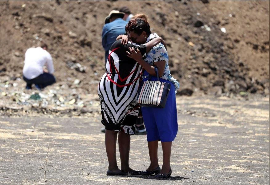 Nhân viên Liên Hiệp Quốc thương tiếc đồng nghiệp tại hiện trường tai nạn chiếc Boeing 737 MAX 8 rơi ở Ethiopia sáng 10-3, trong buổi lễ tưởng niệm 15-3. LHQ có 22 nhân viên thiệt mạng trong chuyến bay này. Ảnh: REUTERS