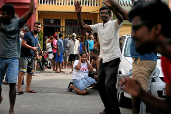 Người dân sống gần khu vực đặc nhiệm đang kiểm tra, rà phá bom trong một xe tải đậu gần một nhà thờ ở thủ đô Colombo (Sri Lanka) ngày 22-4. Ảnh: REUTERS