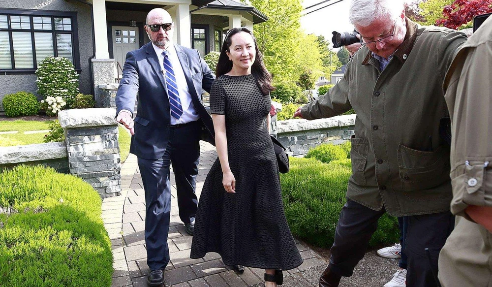 Bà Mạnh Vãn Châu được nhân viên an ninh hộ tống đến tòa án ngày 8-5. Ảnh: AFP