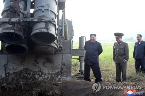 Lãnh đạo Triều Tiên Kim Jong-un đứng bên cạnh một bệ phóng tên lửa đa năng ở tỉnh Nam Pyongan phía tây Triều Tiên khi ông đến quan sát vụ phóng từ 2-3 vật thể nghi là tên lửa, ngày 10-9. Ảnh: YONHAP