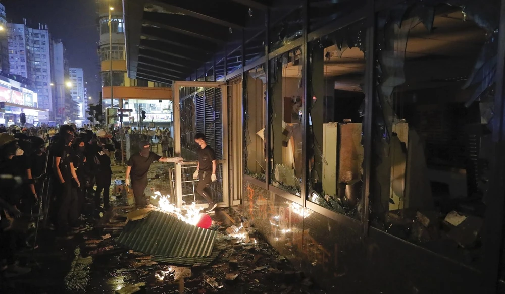 Người biểu tình đập phá một văn phòng chính quyền Hong Kong ngày 1-10. Ảnh: AP