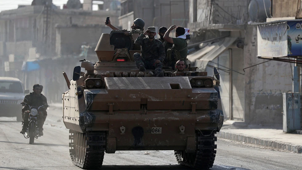Lực lượng tay súng Syria được Thổ Nhĩ Kỳ bảo trợ di chuyển trên đường quốc lộ M4 qua thị trấn Tell Abyad, tỉnh Raqqa ở bắc Syria. Ảnh: REUTERS