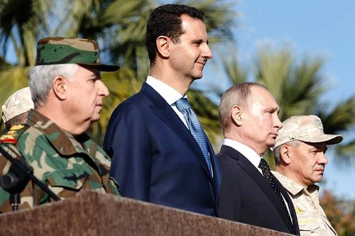 Tổng thống Nga Vladimir Putin (thứ hai từ phải sang) thăm Syria năm 2017, cùng Tổng thống Syria Bashar al-Assad (thứ hai từ trái sang), Bộ trưởng Quốc phòng Nga (phải), Tổng Tham mưu quân đội Syria Ali Abdullah Ayyoub (trái) dự một lễ diễu binh ở tỉnh Latakia (tây bắc Syria). Ảnh: AFP