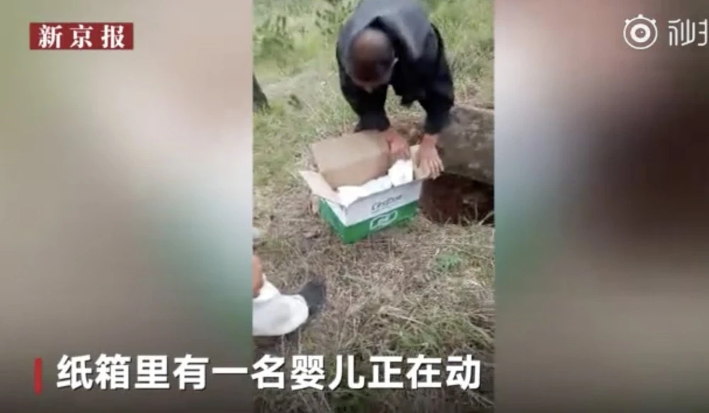 Cậu bé được phát hiện bị đặt trong một thùng giấy chôn dưới hố, có tấm bê tông đậy lên trên. Ảnh: WEIBO