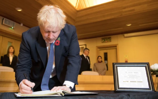 Thủ tướng Anh Boris Johnson viết vào sổ chia buồn với 39 nạn nhân chết trong thùng xe tải ở hạt Essex ngày 28-10. Ảnh: PA
