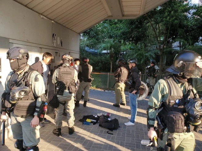 Cảnh sát chặn kiểm tra túi của hai thiếu niên trên đường phố Hong Kong sáng nay. Ảnh: SCMP