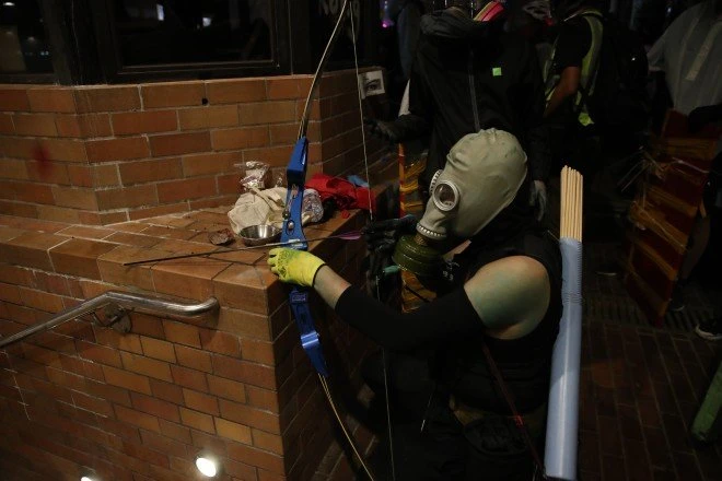 Người biểu tình sử dung cung tên. Ảnh: SCMP